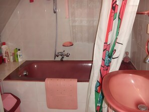 Ein Badezimmer mit einer Badewanne, einem Waschbecken und einer Dusche.
