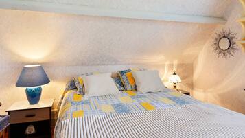 Una camera da letto con un letto, due lampade da comodino, un comodino e un elemento decorativo a parete.