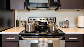 A kitchen with a stove, microwave, and stainless steel appliances.
