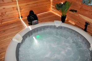 A hot tub with a control panel, surrounded by wooden walls and a potted plant. - Guest Room 'La Parenthèse - Chambre D'hôtes' with Shared Terrace, Wi-Fi and Air Conditioning (Bergerac)