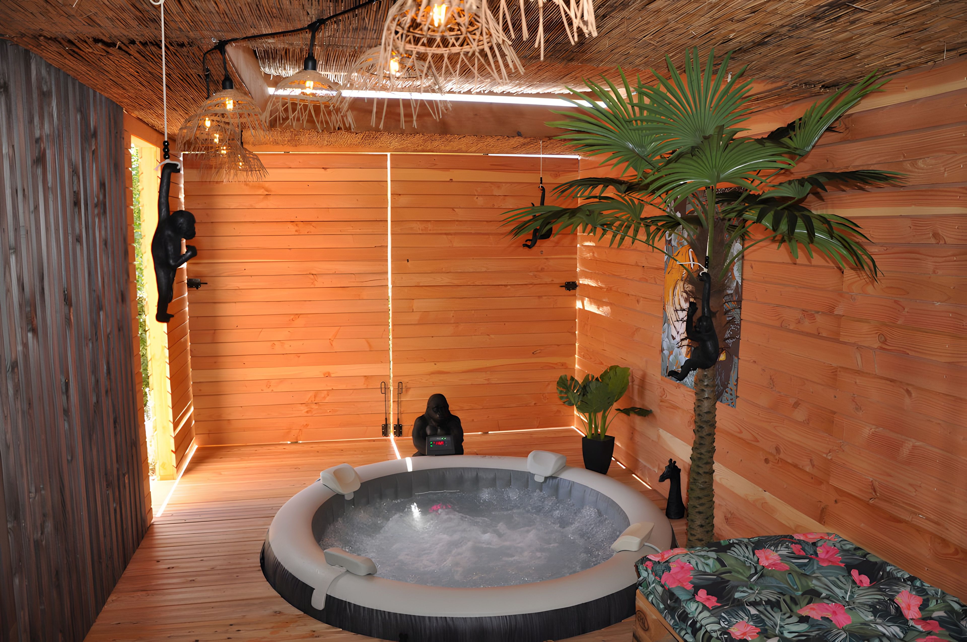 Ein Zimmer mit Holzboden, einer Badewanne, einer Statue und einer Pflanze.