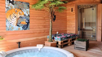 Ein Interieur einer Holzhütte mit Whirlpool, einem Tigerbild und einem kleinen Baum.
