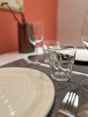 Una mesa con un plato blanco, un vaso y un tenedor.