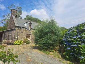 A stone house with a sloped roof, a wooden porch, and a gravel driveway. - Sleeps5-petfriendly-coalfire-snowdonia (Dolgellau)