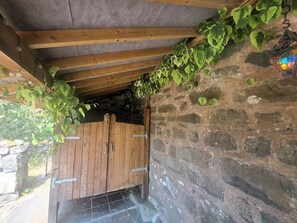A wooden door with metal hinges, a stone wall, and a wooden ceiling with exposed beams. - Sleeps5-petfriendly-coalfire-snowdonia (Dolgellau)