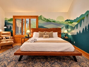A bedroom with a large bed, wooden headboard, and a mountain-themed mural. - 5 Primary En-Suites on First Floor, Hot Tub, Sauna (Wintergreen Resort)