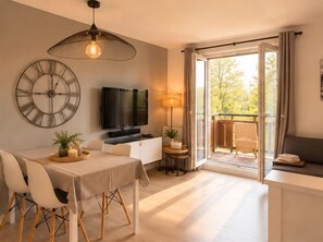 Ein modernes Wohnzimmer mit Essbereich, einem Fernseher und einem Balkon mit einem Stuhl.