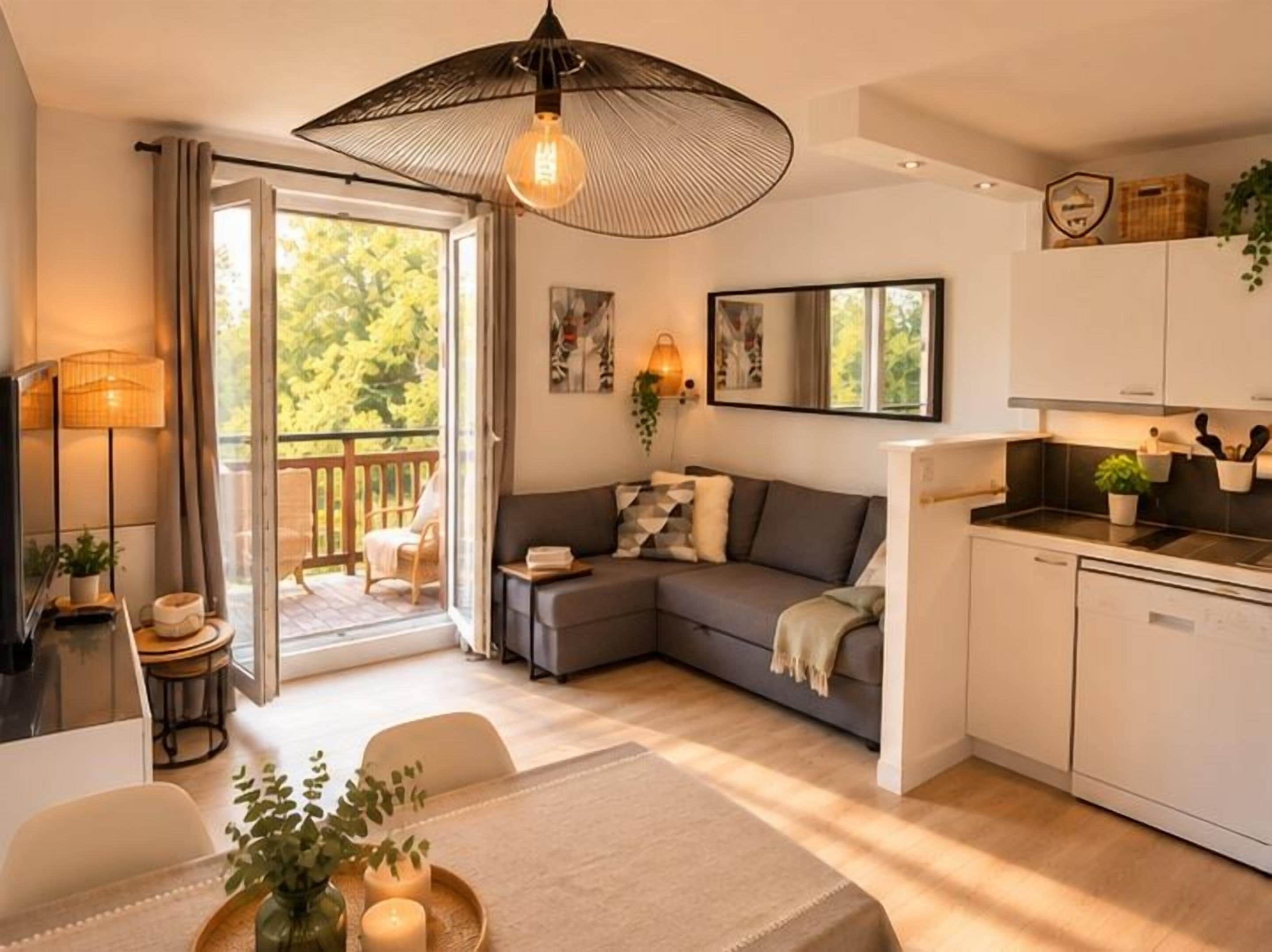 Una sala moderna con sofá, mesa de comedor y zona de cocina.