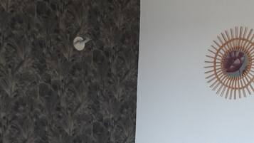 Een slaapkamer met een bed, nachtkastje en wanddecoratie.