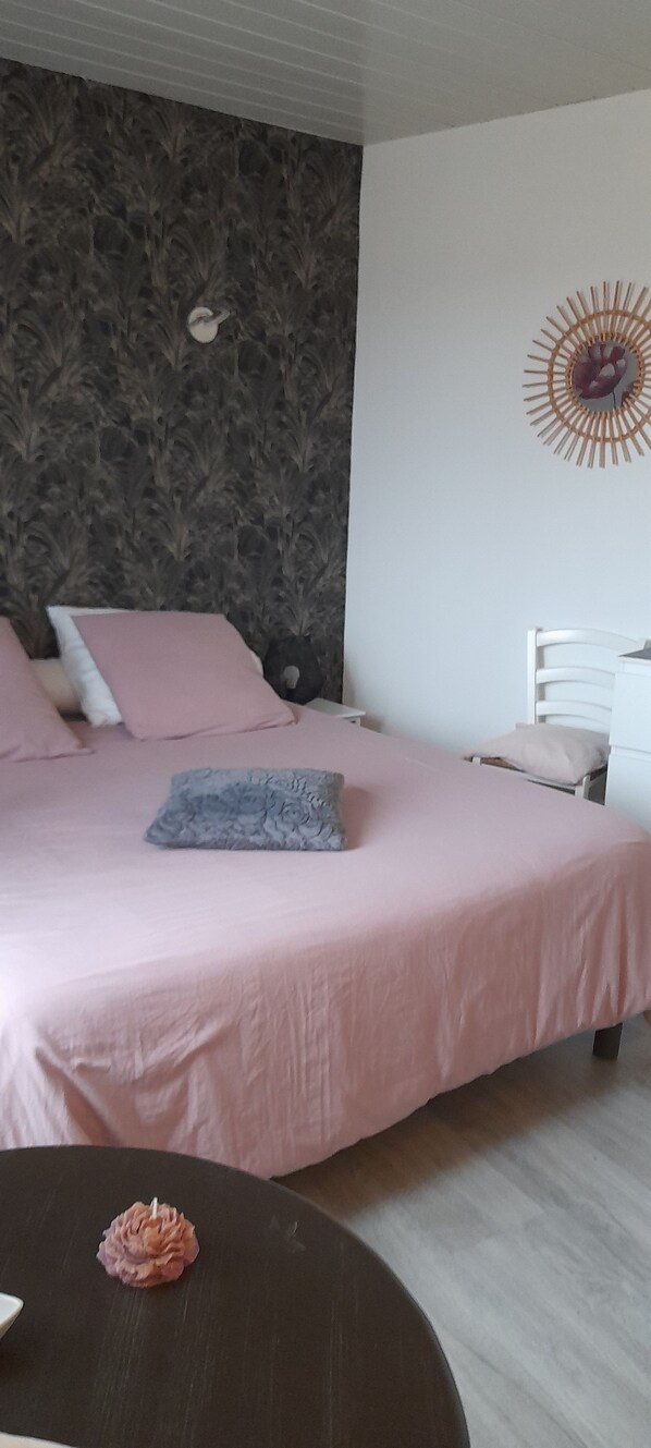 A bedroom with a bed, a nightstand, and a wall decoration.