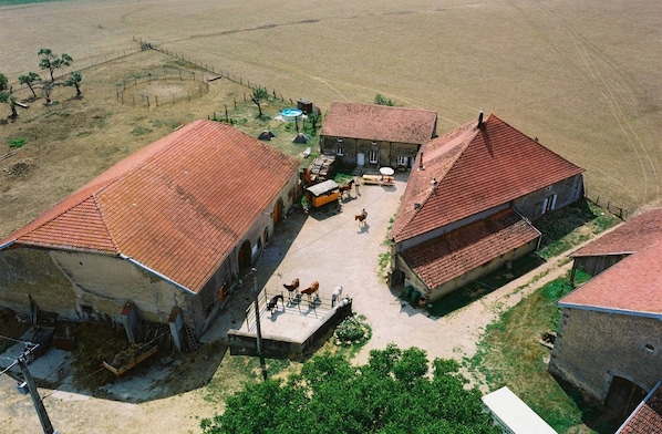 A rural property with multiple buildings, a fenced area, and a small courtyard.