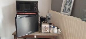 A compact kitchenette with a microwave, toaster, and small refrigerator.