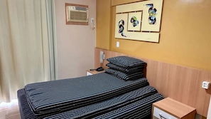 A hotel room with a bed, a bedside table, a mirror, and artwork on the wall. - CRCN - Splendor Thermas (Caldas Novas)