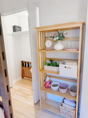 A room with a wooden shelf unit containing various items, a small clock, and a vase with flowers. - Newly Renovated Condo at Ski Wintergreen Resort (Wintergreen Resort)