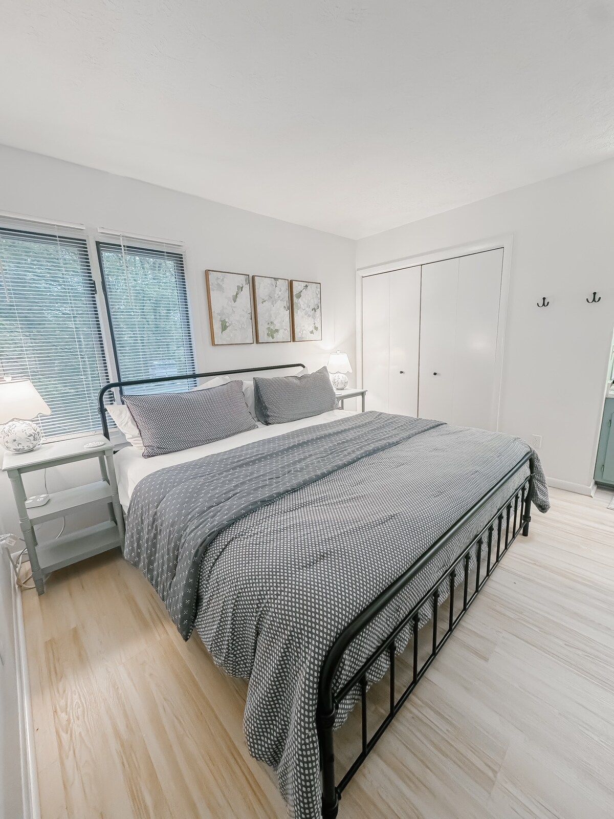 A bedroom with a bed, bedside tables, a lamp, and a wardrobe.