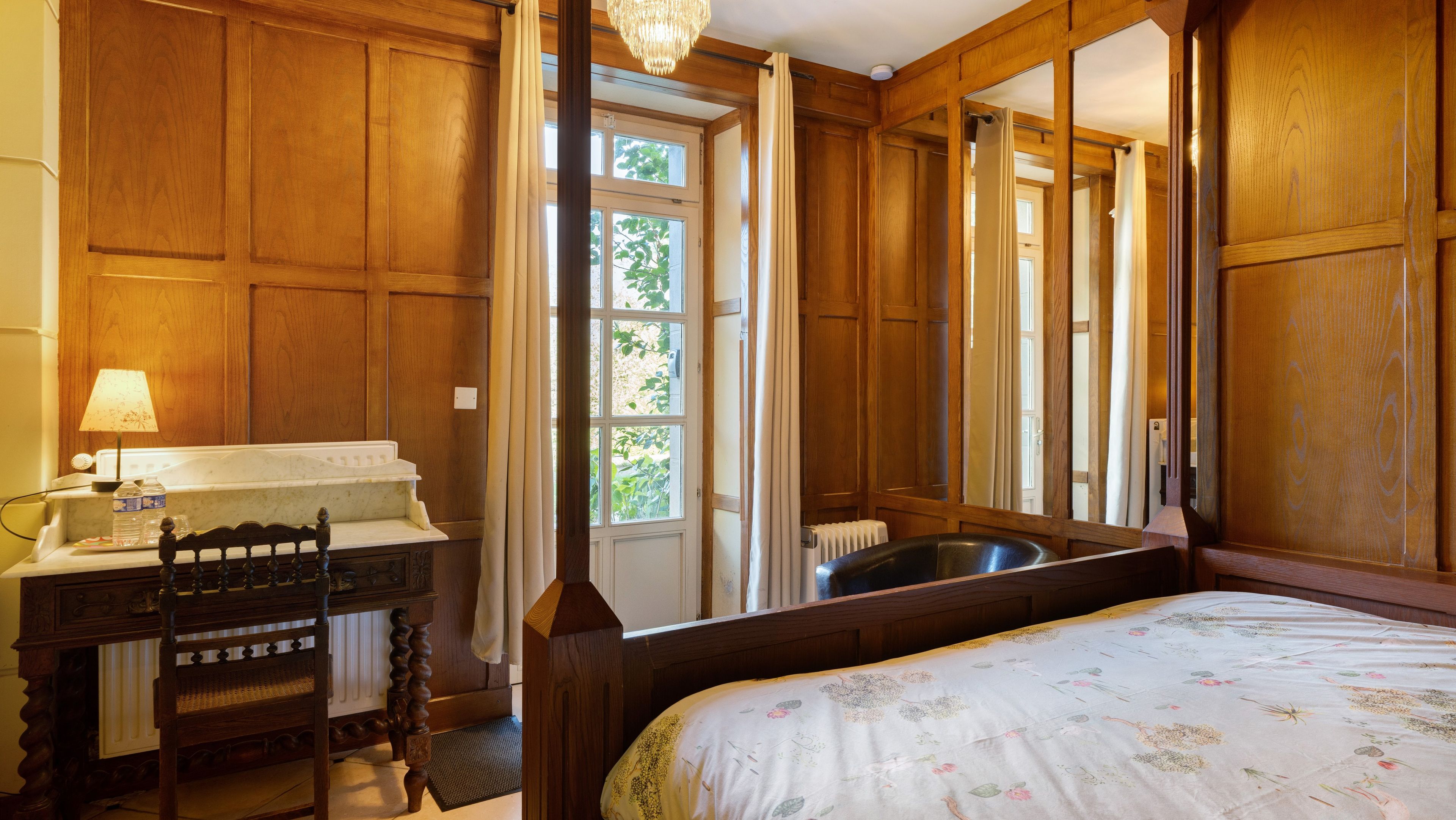 Une pièce avec un cadre en bois, comprenant un lit, un bureau et une fenêtre.