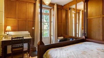 Une pièce avec un cadre en bois, comprenant un lit, un bureau et une fenêtre.