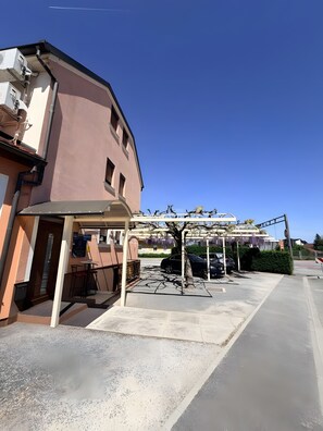 A building with a covered outdoor seating area and a parking lot. - Apartamento 'Baroko Rooms Apartments' con Wi-Fi y aire acondicionado (Varaždin)
