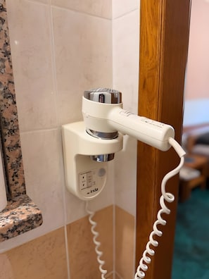 A hairdryer mounted on a wall with a power outlet, a control panel, and a coiled power cord. - Apartamento 'Baroko Rooms Apartments' con Wi-Fi y aire acondicionado (Varaždin)