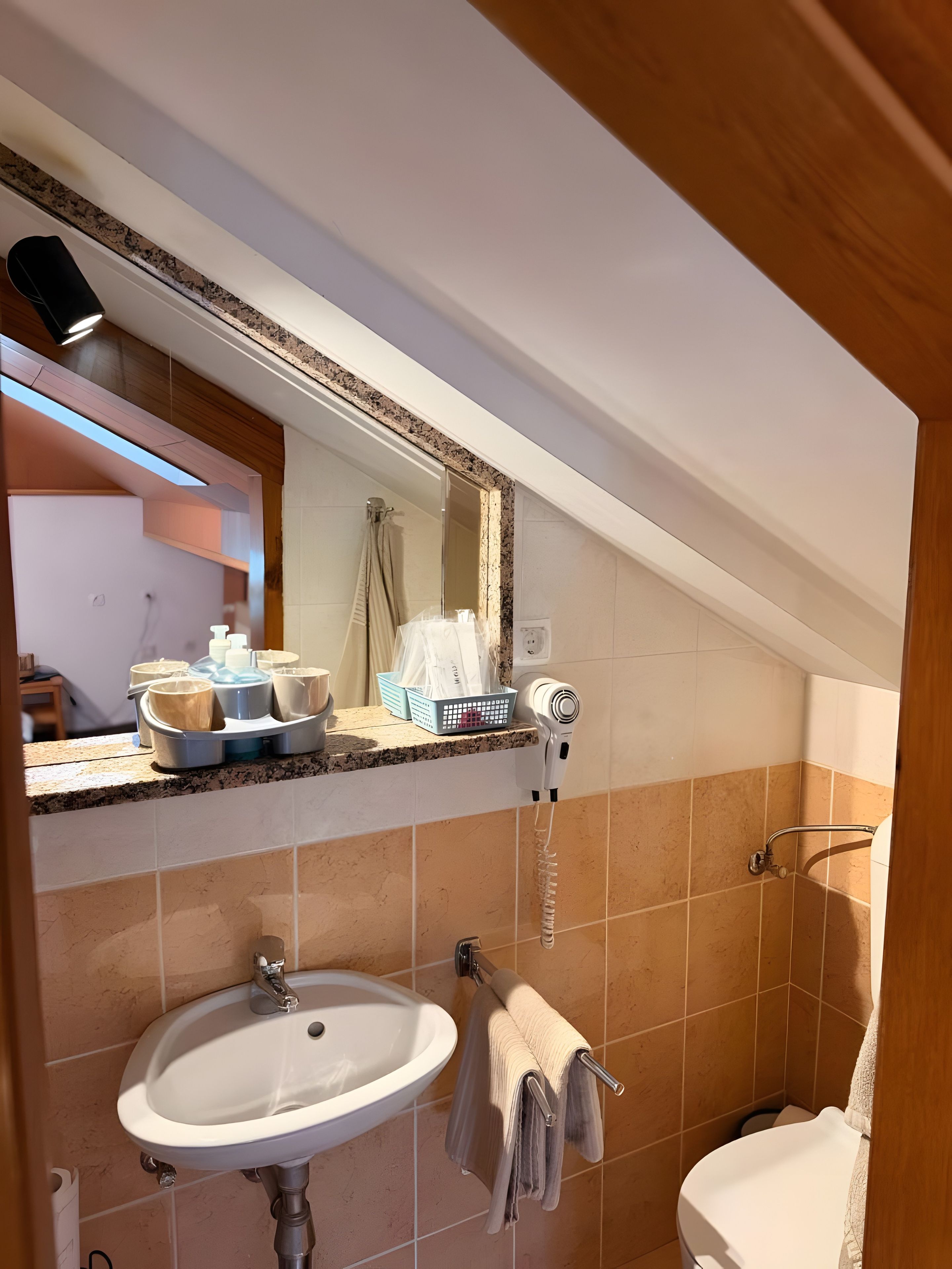 A bathroom with a sink, towel rack, and a hairdryer on the countertop.