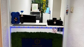 En receptionsdisk med en skylt med texten ”Baroko Rooms & Apartments Reception”.