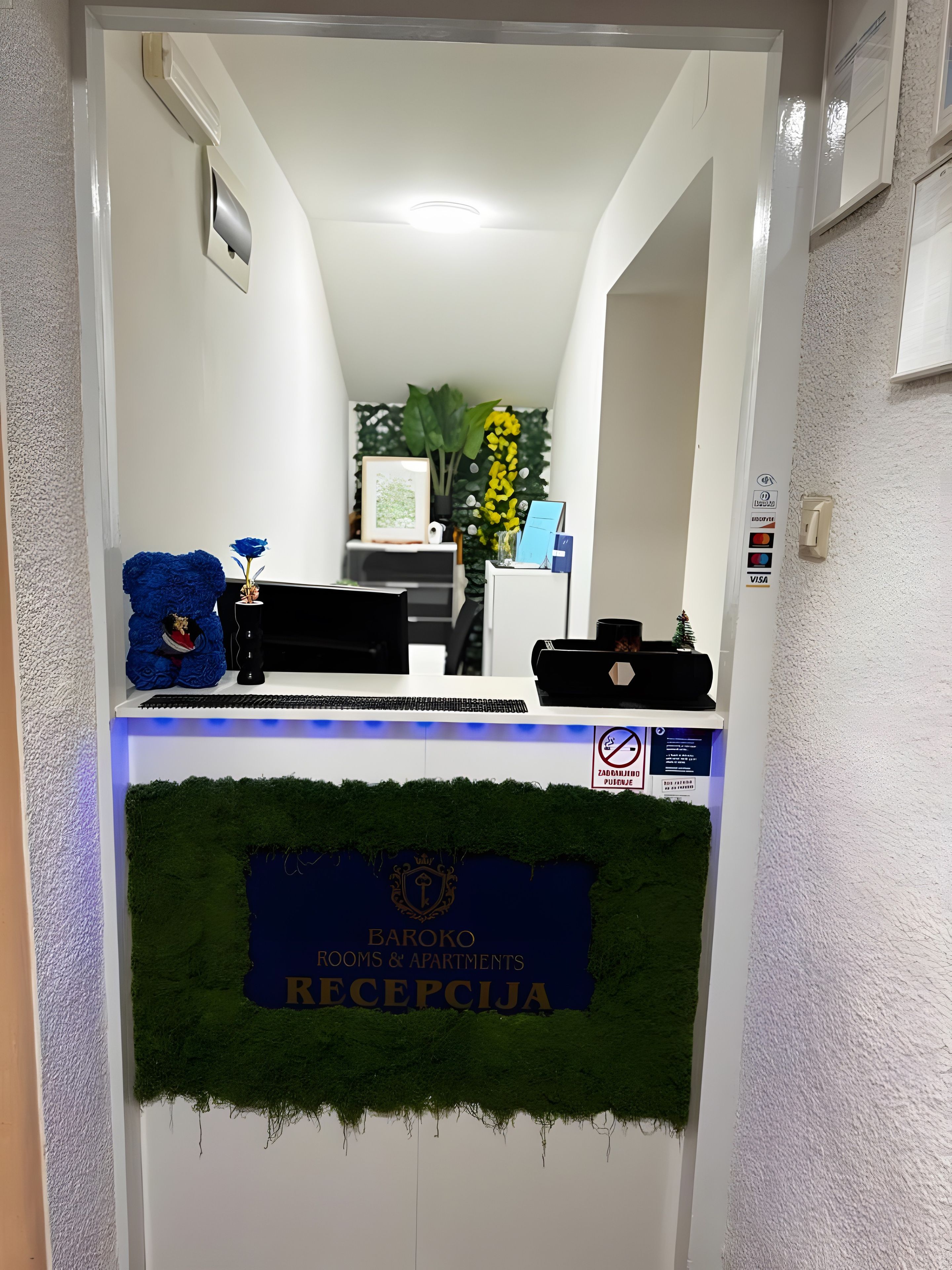 En receptionsdisk med en skylt med texten ”Baroko Rooms & Apartments Reception”.