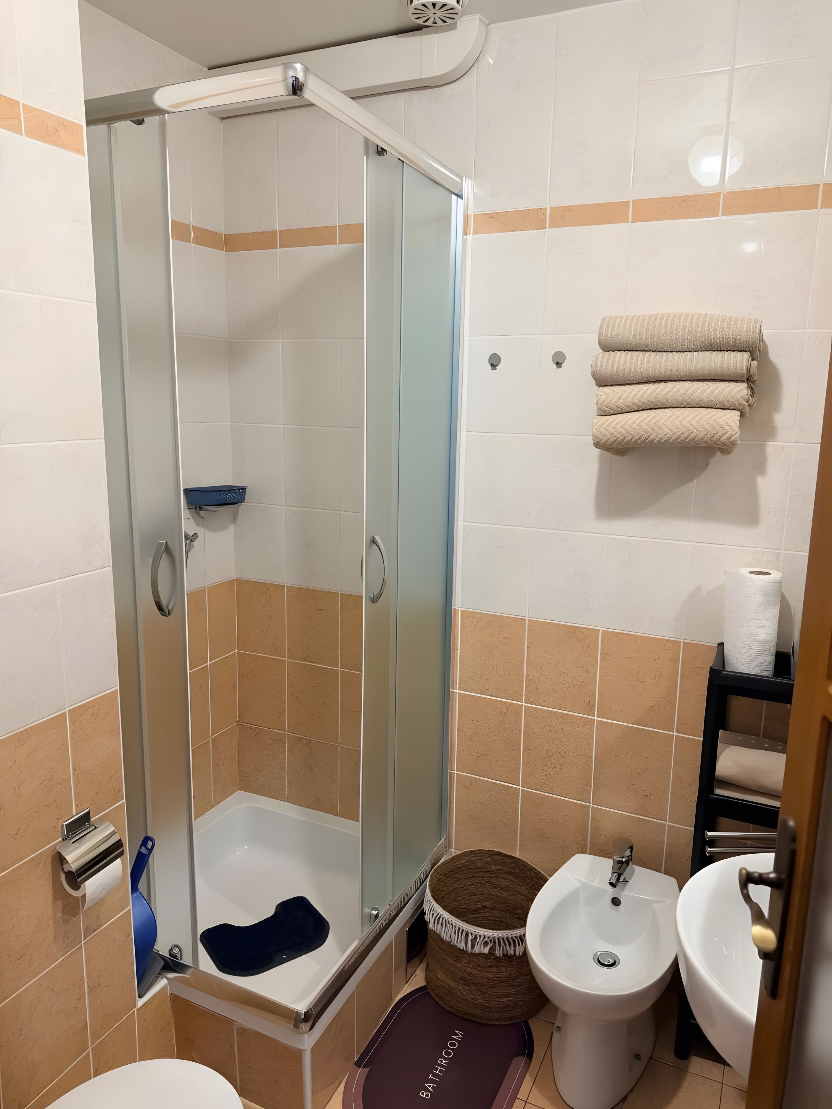 A bathroom with a glass-enclosed shower, a bathtub, a bidet, and a sink.