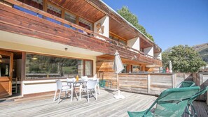 Un edificio in legno con un balcone, posti a sedere all'aperto e vista sul paesaggio.