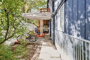 A covered outdoor area with a bicycle, a wooden bench, and a small table. - Lake Thirteen Waterfront Lodge - Fire Pit & Dock (Farwell)