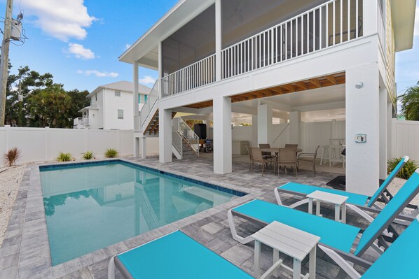 A two-story house with a swimming pool, outdoor furniture, and a covered patio area. - 🌴Sandpiper Shores | Heated Pool + Steps to Beach 🌴 (Fort Myers Beach)