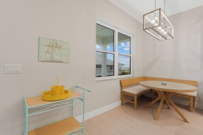 A room with a dining table, bench, and a wall-mounted light fixture. - 🌴Sandpiper Shores | Heated Pool + Steps to Beach 🌴 (Fort Myers Beach)