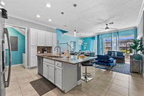 A modern kitchen with white cabinets, a granite countertop, and a central island. - Festival 5BR Pool Townhome w Theme Rooms near WDW (Davenport)