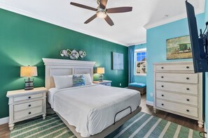 A bedroom with a bed, nightstands, a dresser, a ceiling fan, and a painting on the wall. - Festival 5BR Pool Townhome w Theme Rooms near WDW (Davenport)