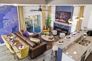 Een moderne woonkamer met een bank, eettafel en een televisie.