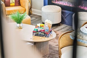 Een gezellige woonkamer met een ronde salontafel, een bank en een televisie.