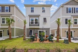 Edificio residencial con patio amoblado y palmeras.