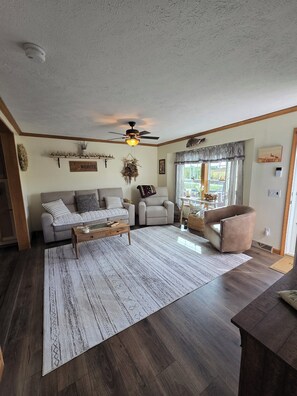 A living room with a ceiling fan, a sofa, a chair, and a coffee table.