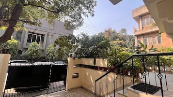 A residential area with a gated entrance, a staircase with a metal railing, and a tiled patio.
