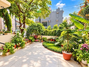 A well-maintained garden with various potted plants and a neatly trimmed lawn.