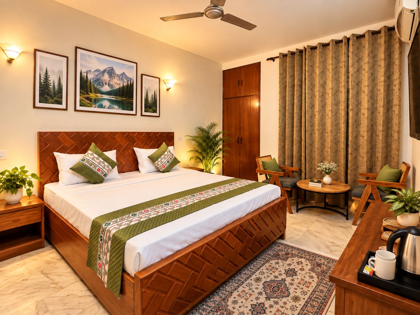 Habitación de hotel con cama, escritorio, silla, mesa, planta, televisor montado en la pared y ventilador de techo.