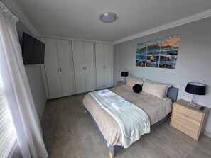 Una camera da letto con un letto, un comodino, un armadio e un quadro appeso al muro.