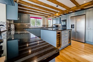 A modern kitchen with a central island, built-in appliances, and a wooden ceiling. - Host & Stay | Yeoman's House (Old Wives Lees)