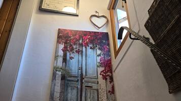 Eine Treppe mit einem gerahmten Zertifikat an der Wand, einer herzförmigen Dekoration und einem Gemälde einer Tür mit Blumen.