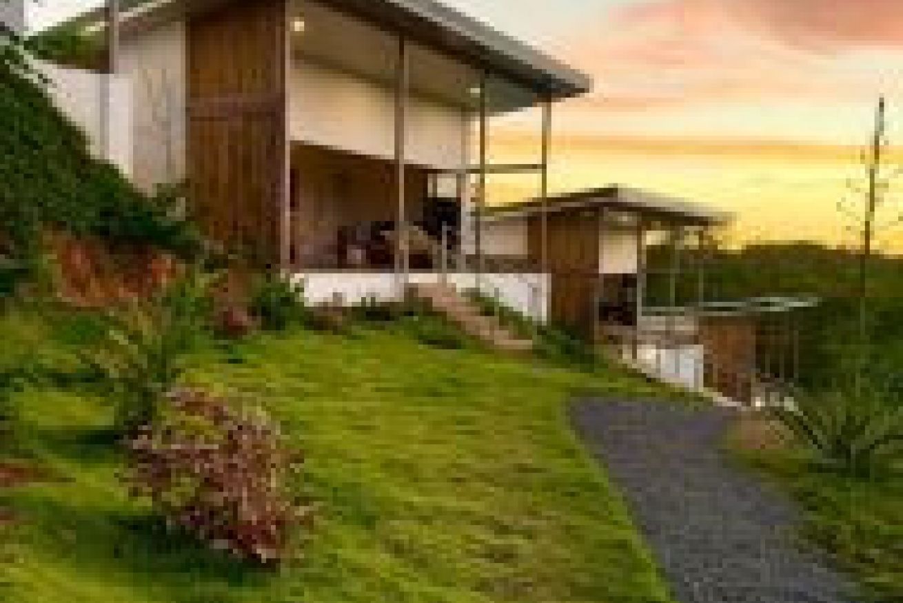 Una casa moderna con porche cubierto y entrada pavimentada.