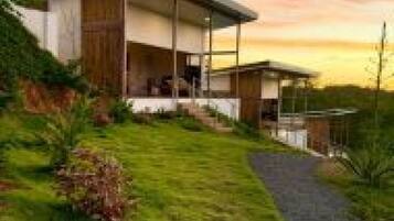 Una casa moderna con porche cubierto y entrada pavimentada.