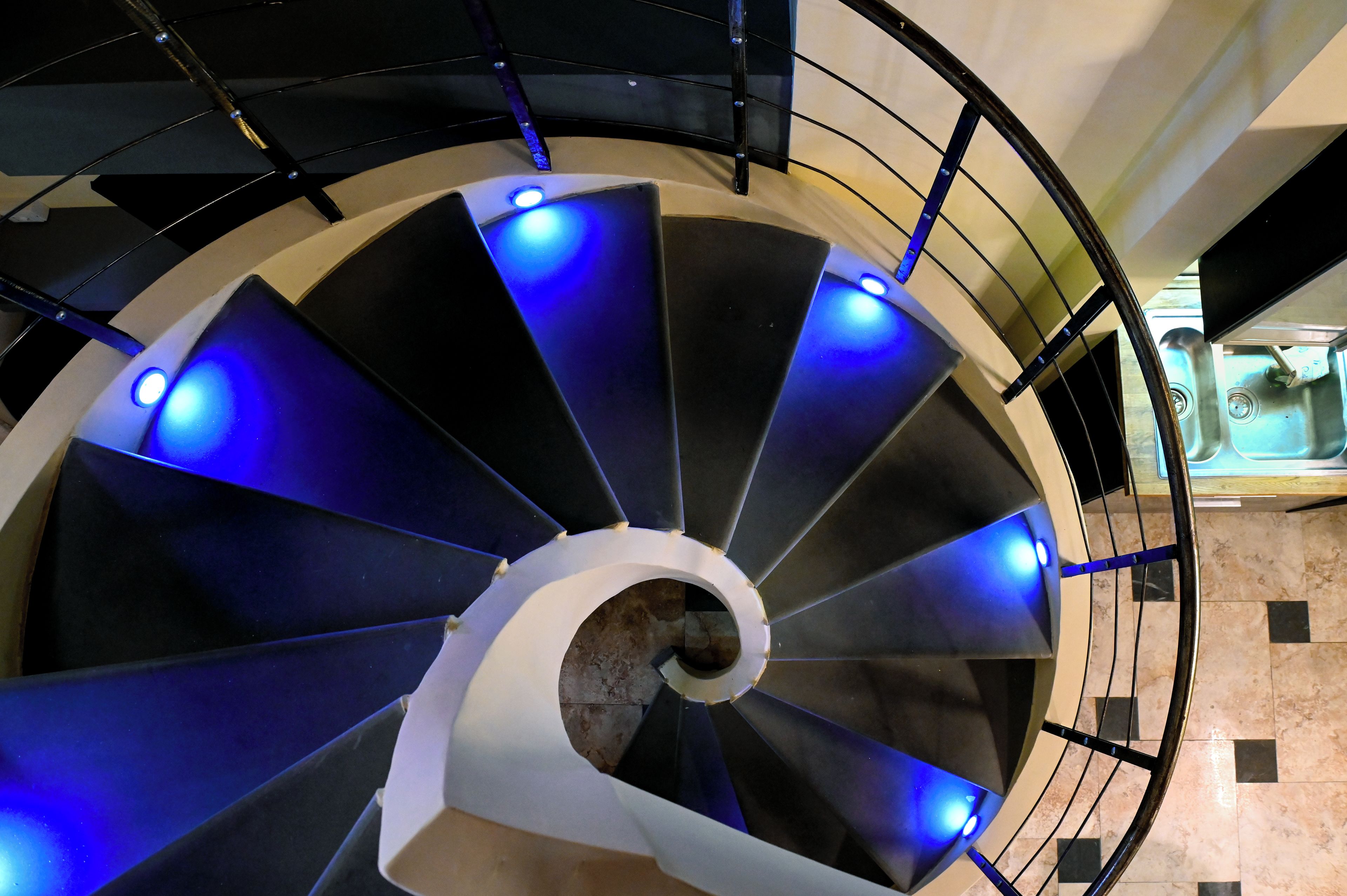 A spiral staircase with blue lighting.