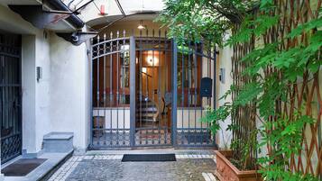 A gated entrance with a cobblestone pathway leading to a building.