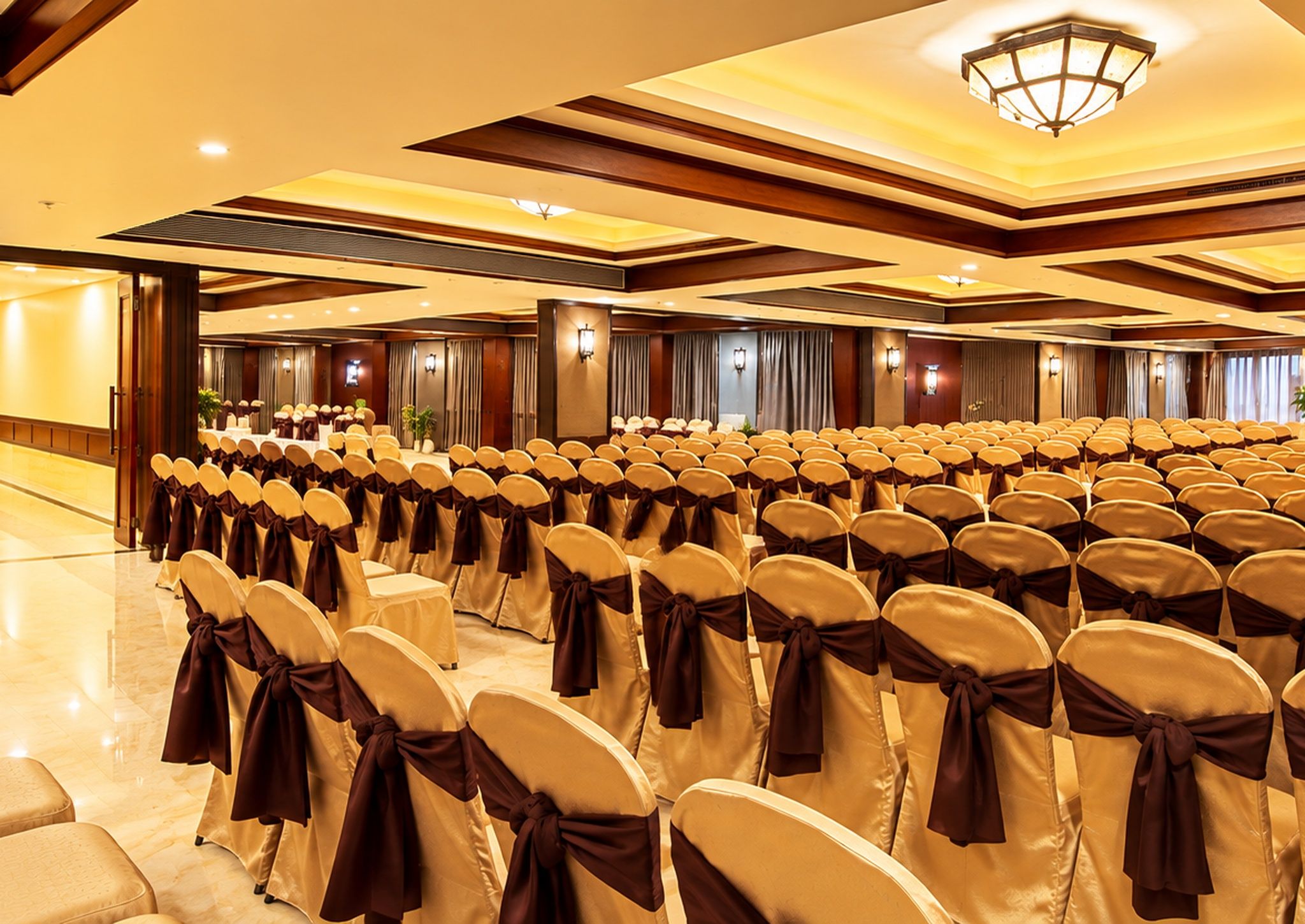 Un salón de conferencias con filas de sillas, cada una con un lazo marrón, y un escenario con un atril.