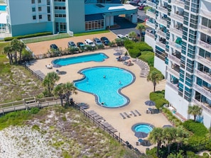 A hotel with a large outdoor swimming pool, multiple lounge areas, and a parking lot. - Palacio 603 (Pensacola)