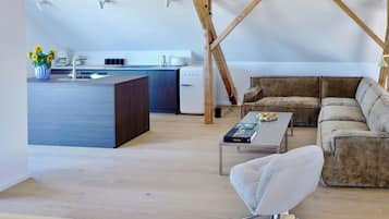 A modern loft with a kitchen, a sofa, and a coffee table.